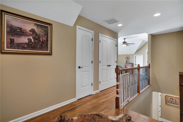 hall featuring light wood-type flooring and vaulted ceiling