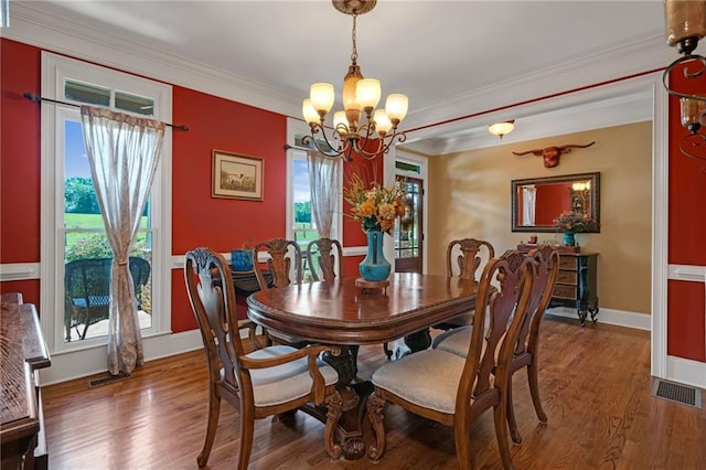 dining room featuring a chandelier, hardwood / wood-style floors, and crown molding