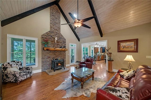 living room with beam ceiling, a wood stove, wood ceiling, hardwood / wood-style floors, and high vaulted ceiling