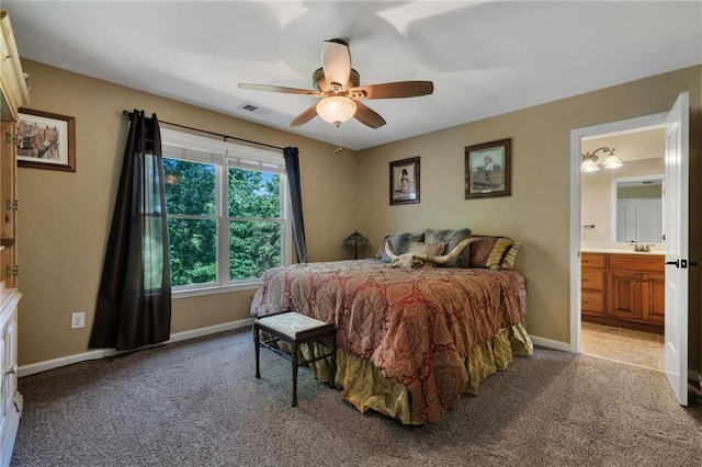 bedroom with sink, light colored carpet, ensuite bath, and ceiling fan