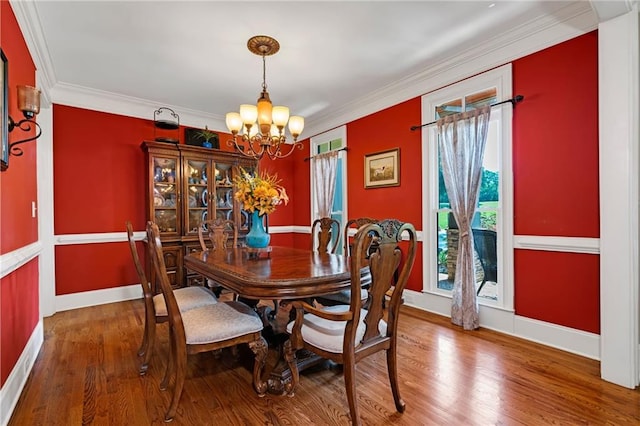 dining space featuring a chandelier, a wealth of natural light, crown molding, and hardwood / wood-style floors