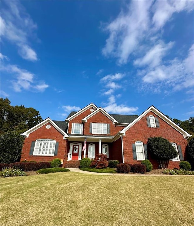 view of front facade with a front lawn and brick siding