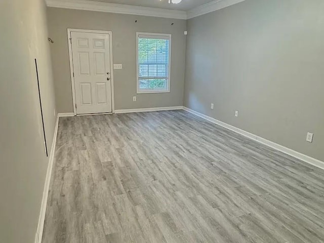 spare room featuring ceiling fan, light hardwood / wood-style floors, and crown molding