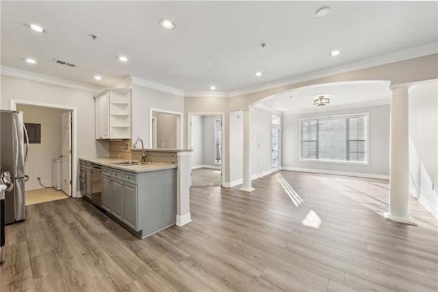 kitchen featuring sink, light hardwood / wood-style flooring, gray cabinets, appliances with stainless steel finishes, and decorative columns