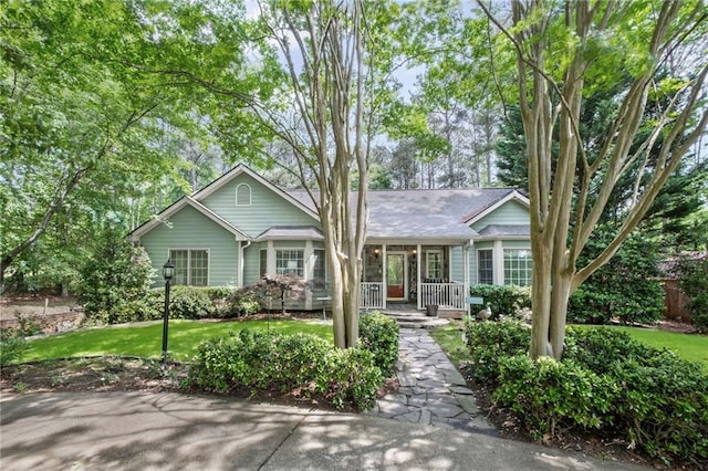 ranch-style house featuring a porch and a front lawn