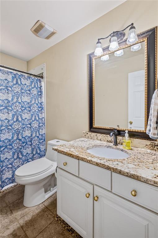 bathroom with vanity, toilet, tile patterned floors, a shower with shower curtain, and visible vents