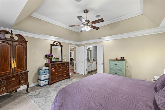 bedroom featuring a tray ceiling, light carpet, ornamental molding, and ensuite bath