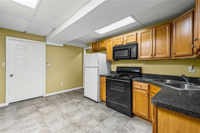 kitchen featuring a sink, dark countertops, black appliances, and a drop ceiling