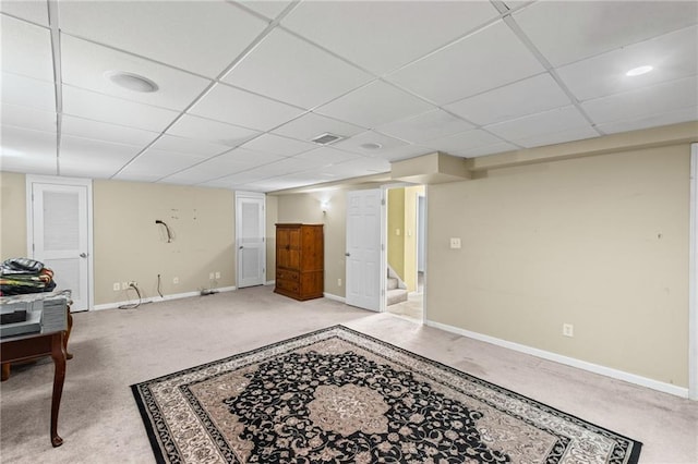 finished below grade area featuring carpet flooring, baseboards, visible vents, and stairs