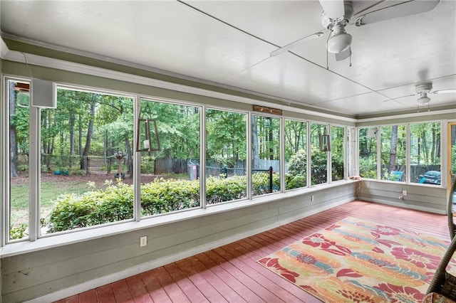 unfurnished sunroom featuring crown molding, wood-type flooring, and a healthy amount of sunlight