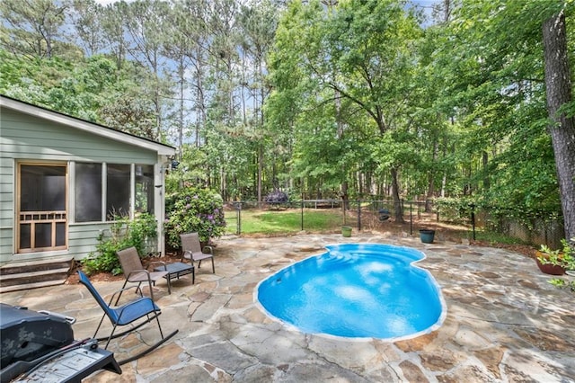 view of swimming pool with a fenced backyard, a fenced in pool, a sunroom, a patio area, and entry steps