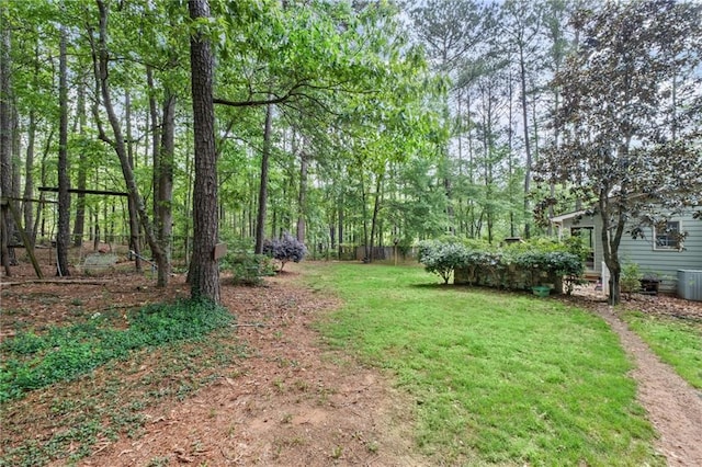 view of yard with central AC and fence