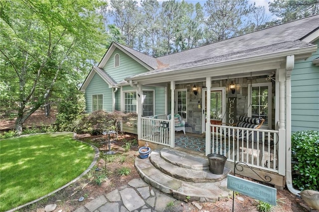 exterior space featuring roof with shingles, a yard, and covered porch