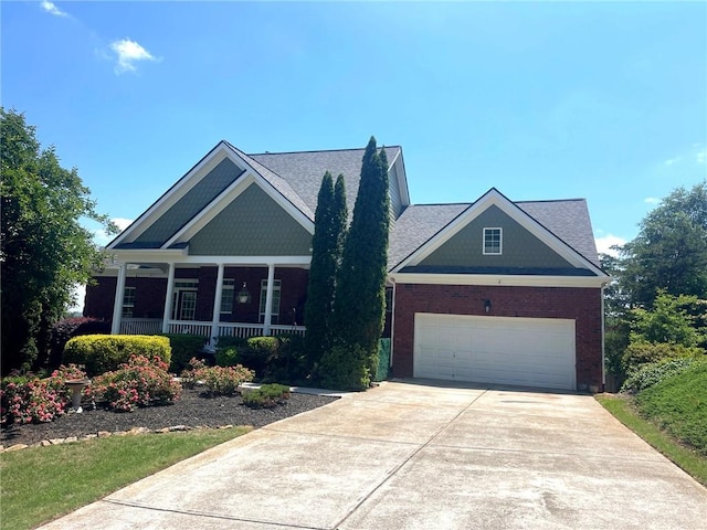 view of front of property featuring concrete driveway, brick siding, a porch, and a garage