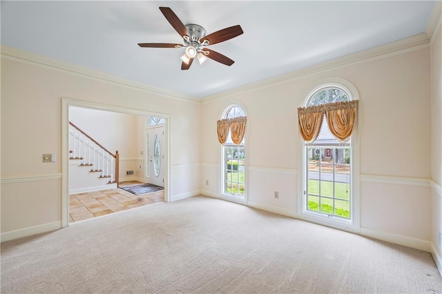 unfurnished room featuring carpet flooring, a healthy amount of sunlight, stairway, and ornamental molding