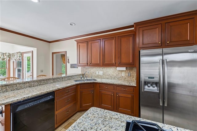 kitchen with light stone counters, stainless steel fridge, a sink, black dishwasher, and backsplash