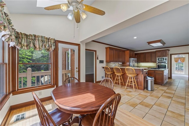 dining room featuring light tile patterned floors, baseboards, ceiling fan, and visible vents