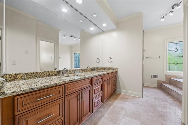 bathroom featuring track lighting, a sink, plenty of natural light, visible vents, and ornamental molding