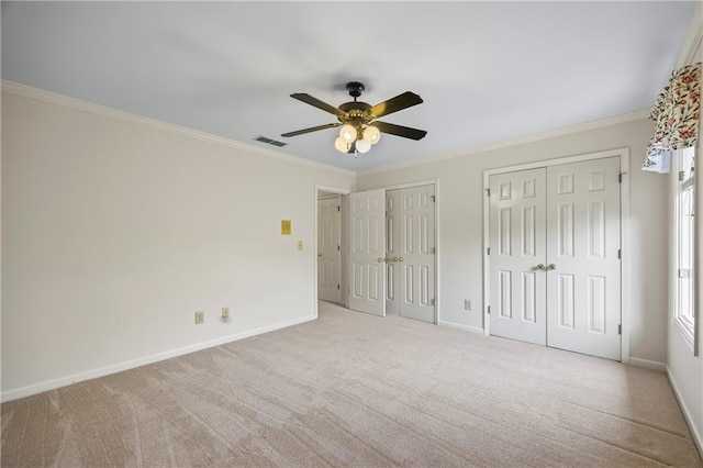 unfurnished bedroom with visible vents, carpet, baseboards, and two closets