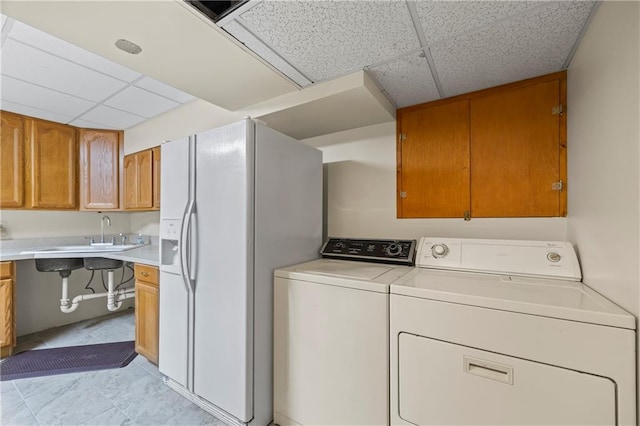 washroom featuring laundry area, a sink, light tile patterned flooring, and washer and dryer