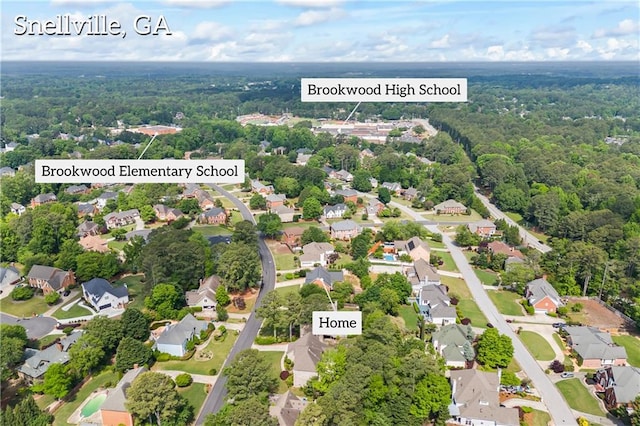 drone / aerial view featuring a residential view and a wooded view
