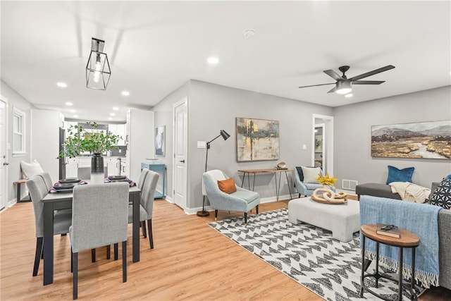 dining space with ceiling fan and light wood-type flooring