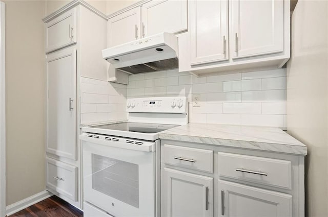 kitchen featuring white range with electric stovetop, under cabinet range hood, decorative backsplash, dark wood finished floors, and baseboards
