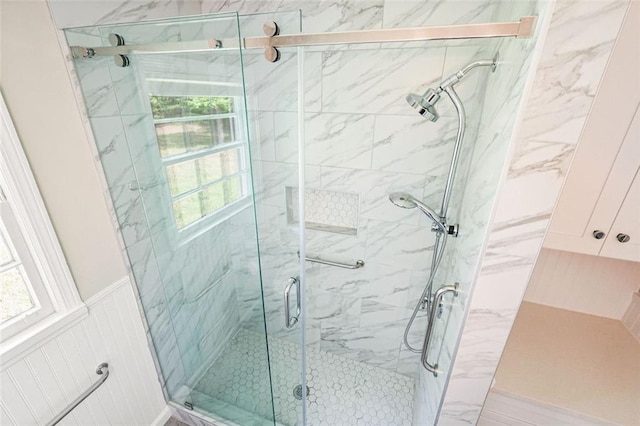 bathroom with healthy amount of natural light and a marble finish shower