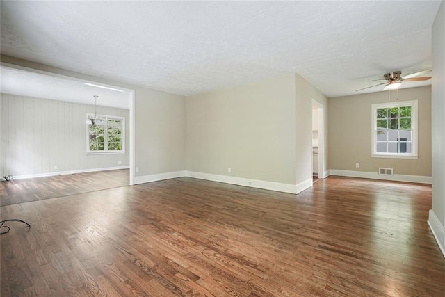 unfurnished living room featuring wood finished floors, a ceiling fan, a textured ceiling, and baseboards