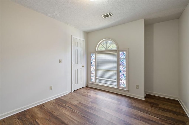 entrance foyer with a textured ceiling and dark hardwood / wood-style floors