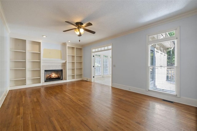 unfurnished living room featuring wood-type flooring, ceiling fan, a fireplace, and a textured ceiling