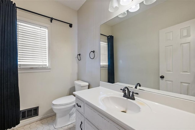 bathroom featuring tile patterned flooring, toilet, and vanity