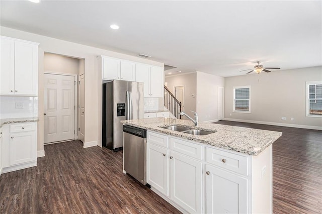 kitchen featuring dark wood-style flooring, backsplash, appliances with stainless steel finishes, white cabinetry, and a sink