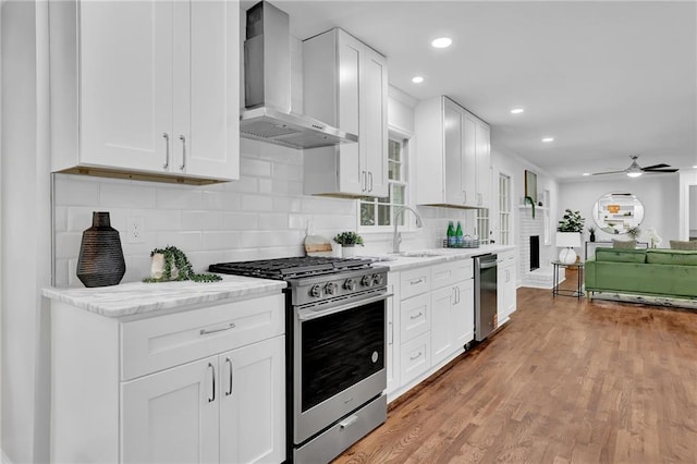 4669 Dunover Cir, Atlanta, GA 30360 - kitchen with stainless steel appliances, wall chimney exhaust hood, backsplash, a ceiling fan, and white cabinets