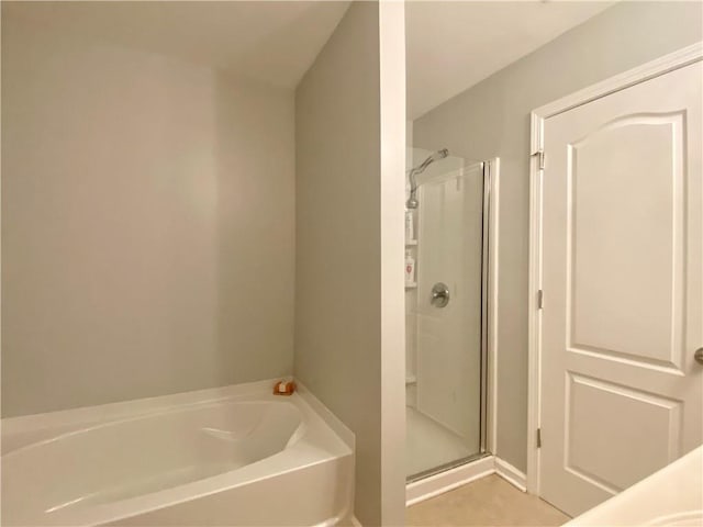 bathroom featuring a stall shower and a garden tub