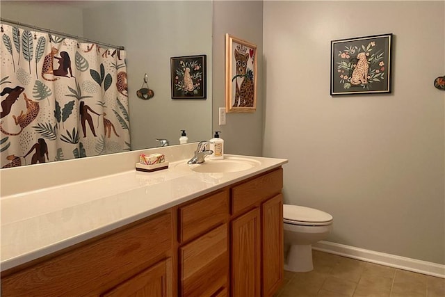 bathroom featuring tile patterned flooring, baseboards, vanity, and toilet