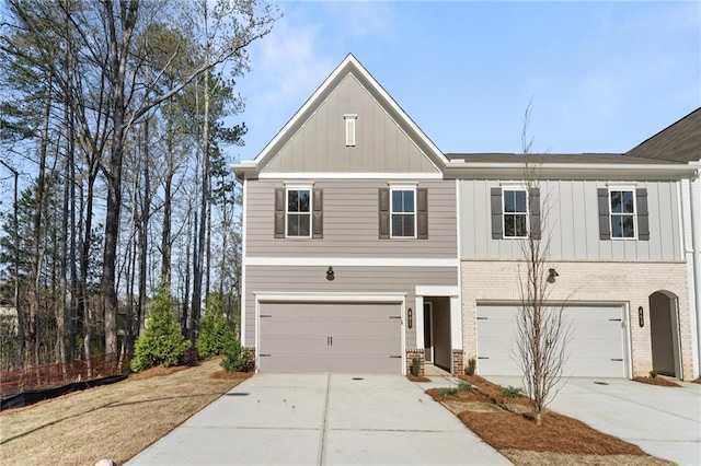 view of front of house with a garage, board and batten siding, driveway, and brick siding