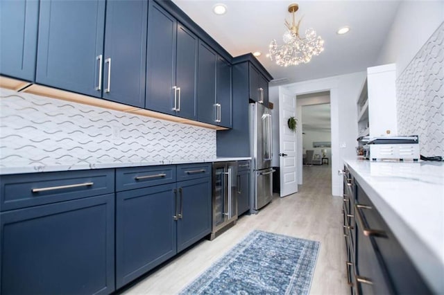 kitchen featuring beverage cooler, high end fridge, blue cabinetry, and backsplash