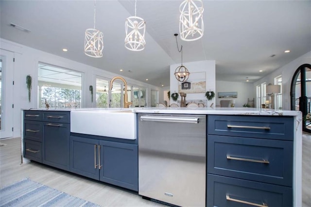 kitchen with pendant lighting, stainless steel dishwasher, light wood-style floors, open floor plan, and a sink