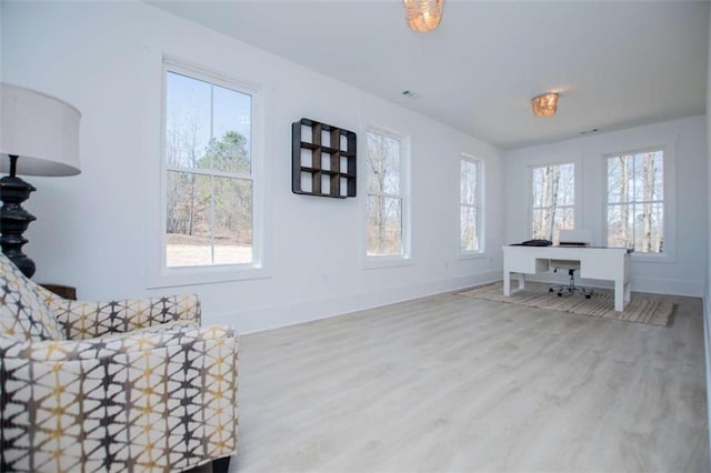 living area featuring plenty of natural light, baseboards, and wood finished floors