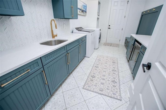 clothes washing area featuring cabinet space, a sink, washer and clothes dryer, and light tile patterned flooring