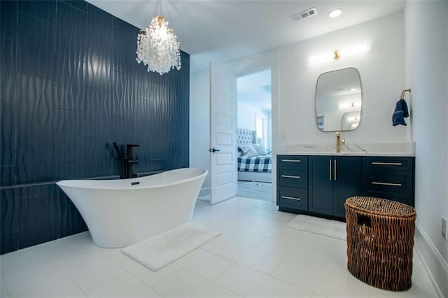 full bath with visible vents, ensuite bathroom, an inviting chandelier, a freestanding bath, and vanity