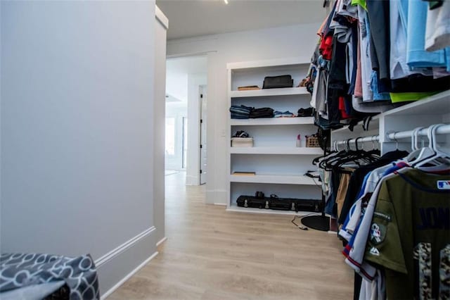 walk in closet with wood finished floors