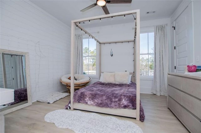 bedroom with a ceiling fan, visible vents, and light wood-style floors