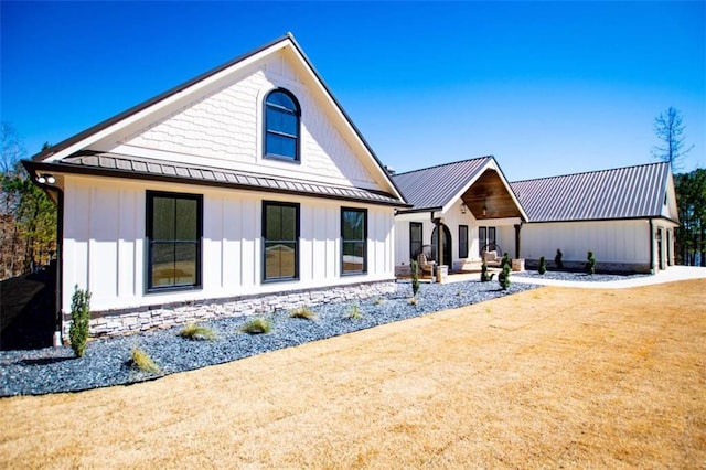 rear view of property with a standing seam roof, metal roof, and board and batten siding