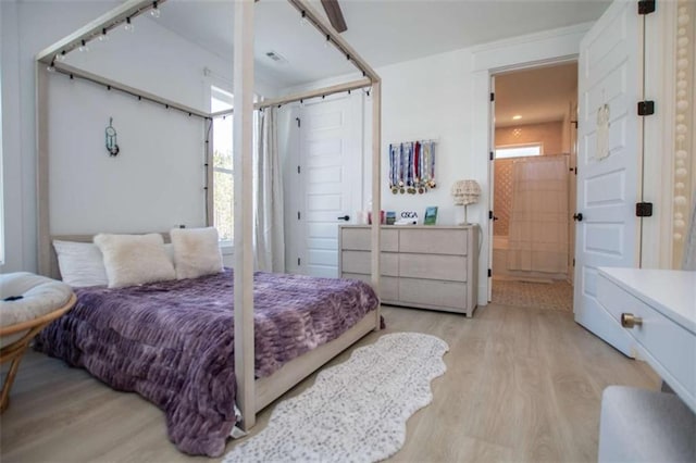 bedroom featuring wood finished floors and connected bathroom