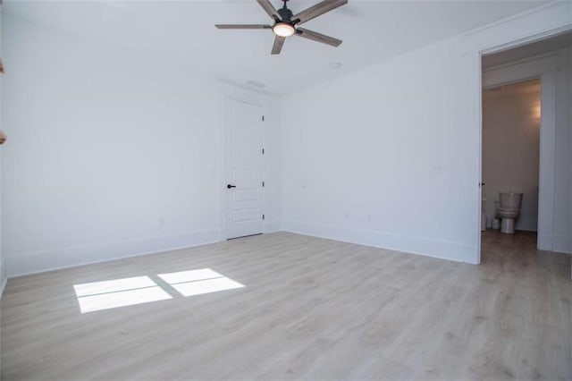 unfurnished room with ceiling fan, light wood finished floors, and baseboards