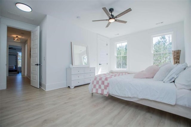 bedroom featuring light wood-style floors, baseboards, and a ceiling fan