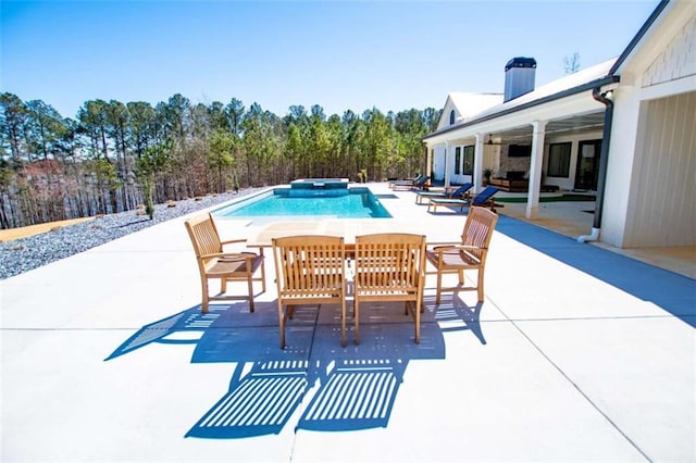 view of pool with a pool with connected hot tub and a patio