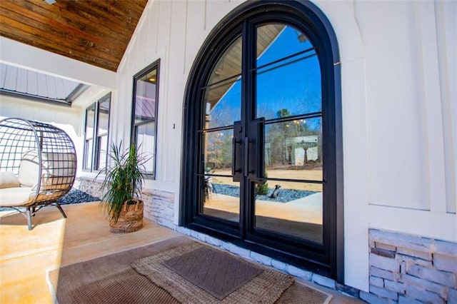 entryway with a sunroom, wood ceiling, arched walkways, and vaulted ceiling